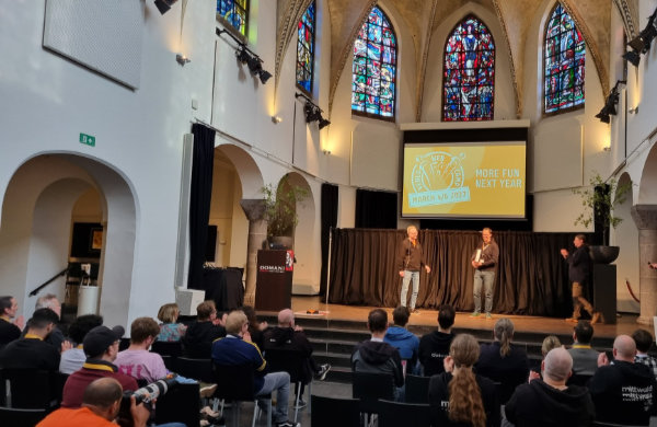 Blick auf die Bühne einer umgebauten Kirche, im Vordergrund Stühle mit Publikum
